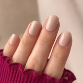 Crema press-on nails — glossy fingertip close-up