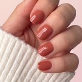 Terracotta press-on nails — glossy fingertip close-up