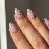Cobweb press-on nails — glossy fingertip close-up
